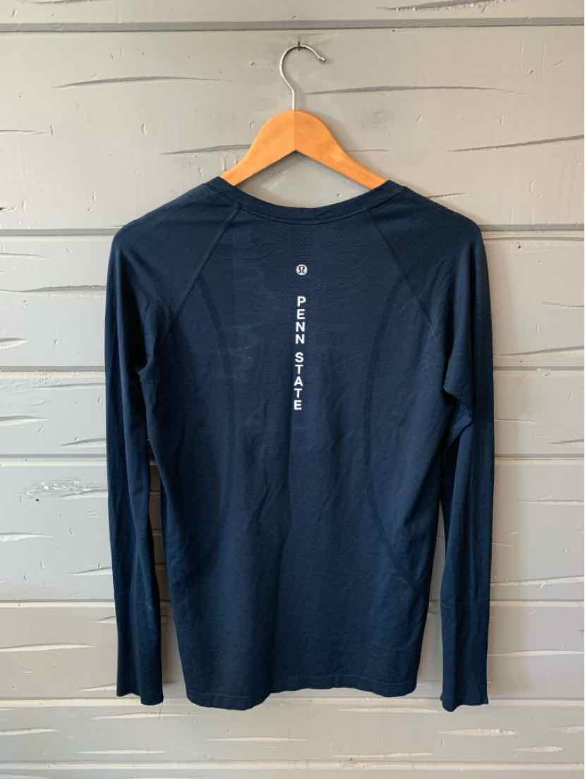 Black long-sleeve athletic shirt with slim fit and vertical white logo text down the center back.