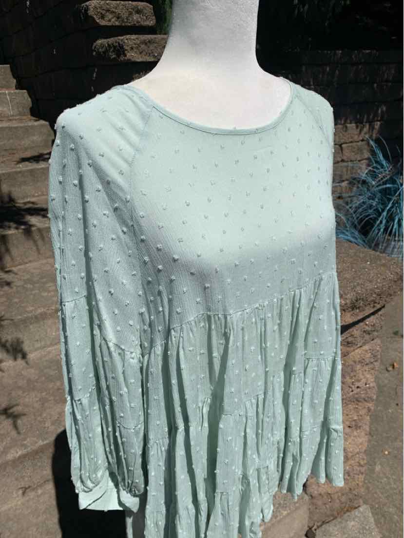 Light green long-sleeve blouse with textured dotted fabric and flowy gathered waist.