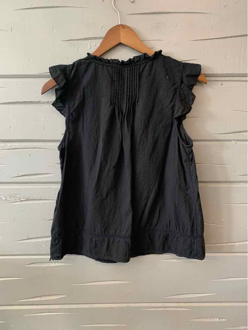 Black sleeveless blouse with ruffled neckline and pleated front on wooden hanger.