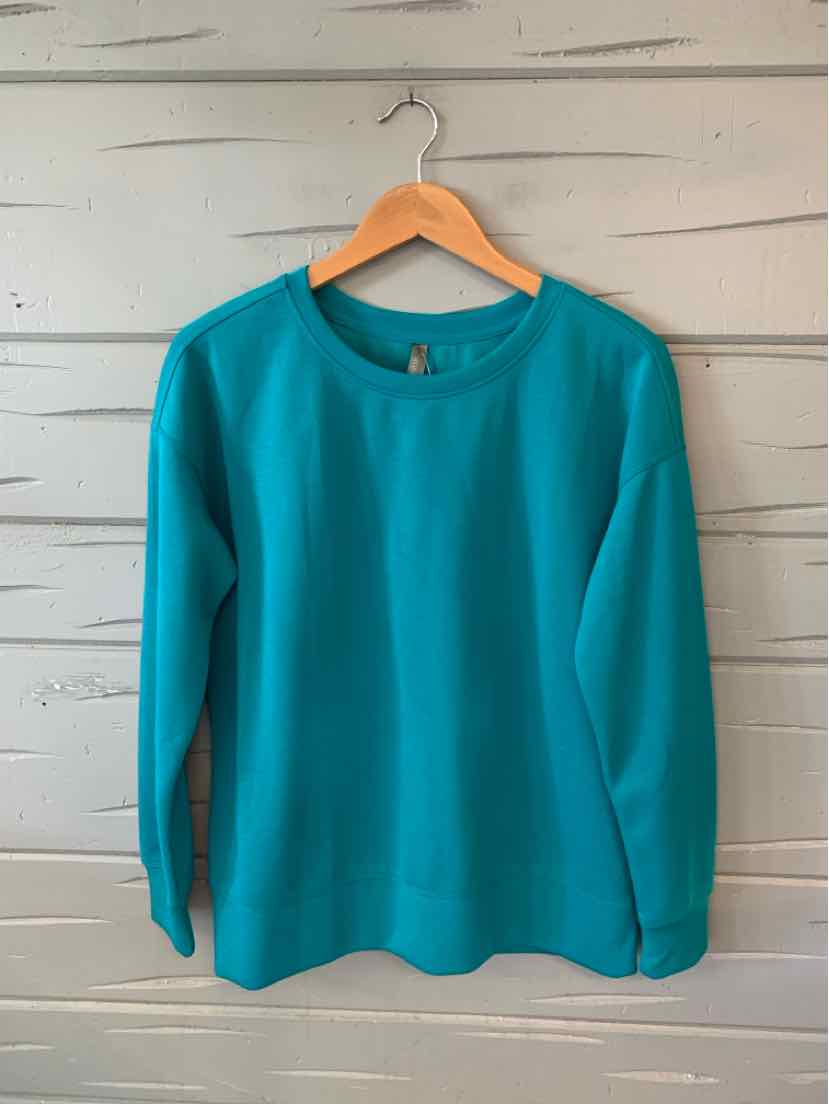 Teal long-sleeve crewneck sweatshirt with a relaxed fit, displayed on a wooden hanger against a white shiplap wall.