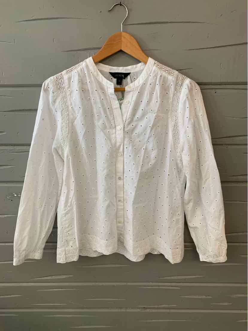 White long-sleeve eyelet blouse with button-front and band collar on wooden hanger.