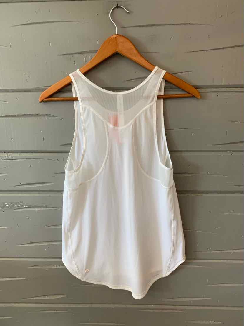 White sleeveless athletic tank top with racerback design and lightweight fabric, hanging on wooden hanger.