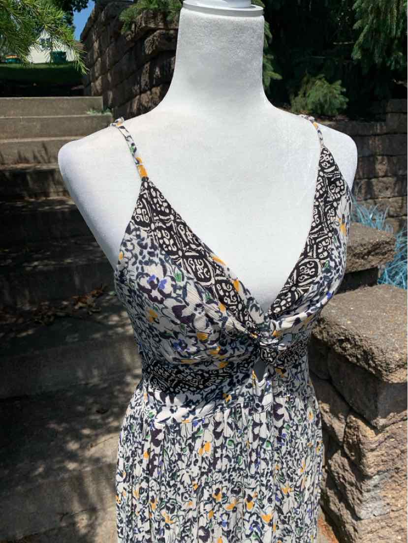Floral print sleeveless dress with thin straps, V-neckline, and cinched waist in muted colors.