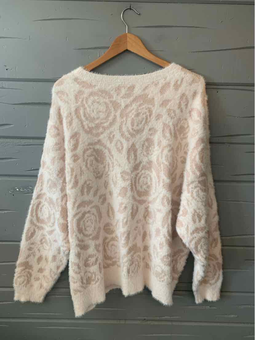 Soft pink floral-patterned knit sweater with long sleeves, size 3X, hanging on wooden hanger.