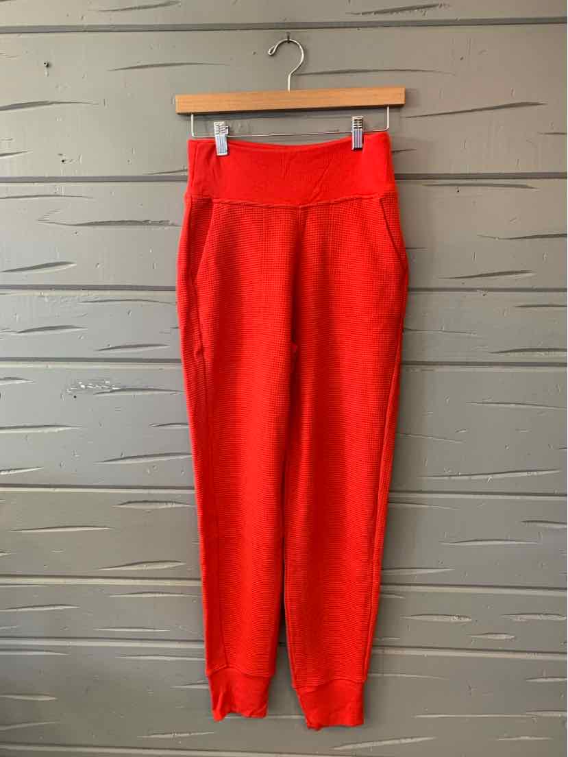 Bright red women’s waffle-knit jogger pants with a wide waistband and tapered ankles.