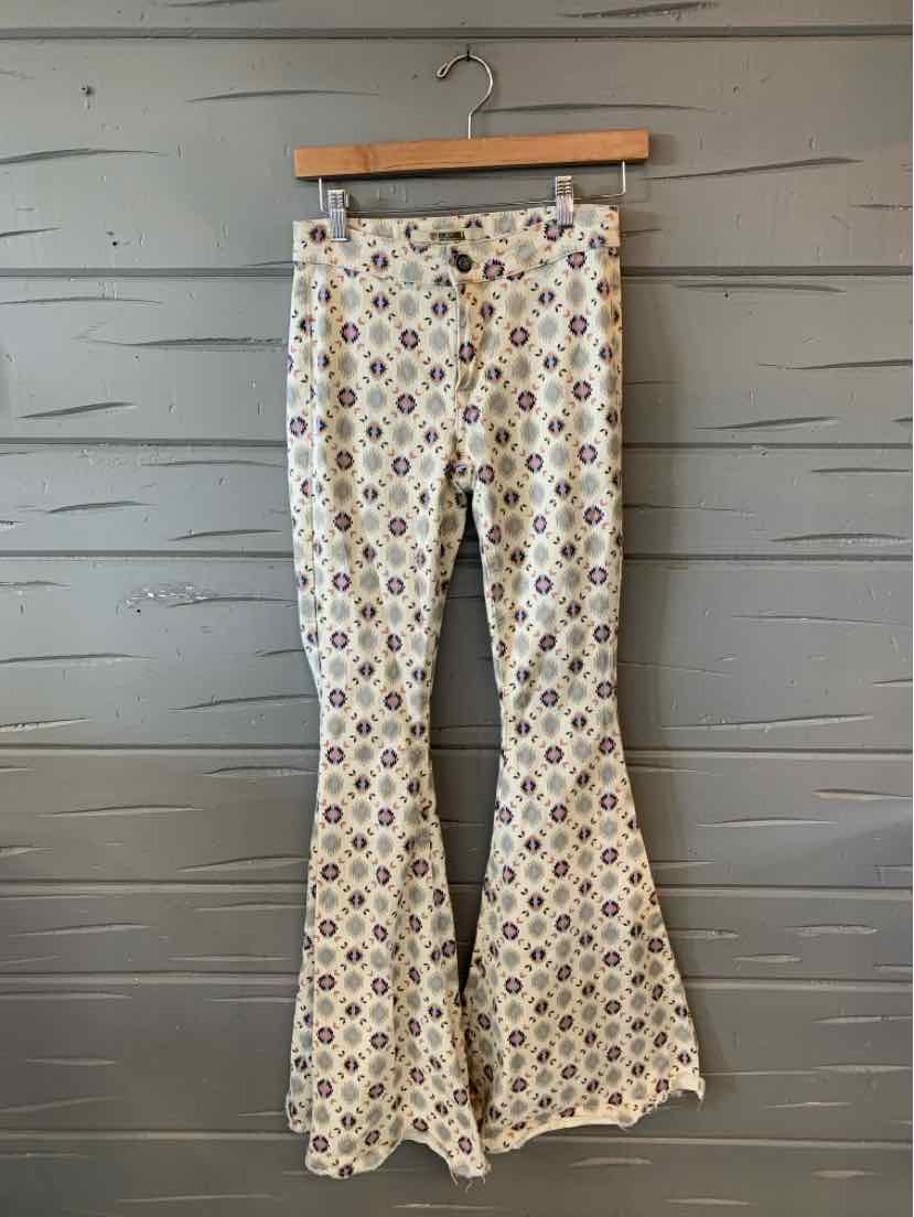 High-waisted flared pants with colorful geometric pattern on cream fabric.