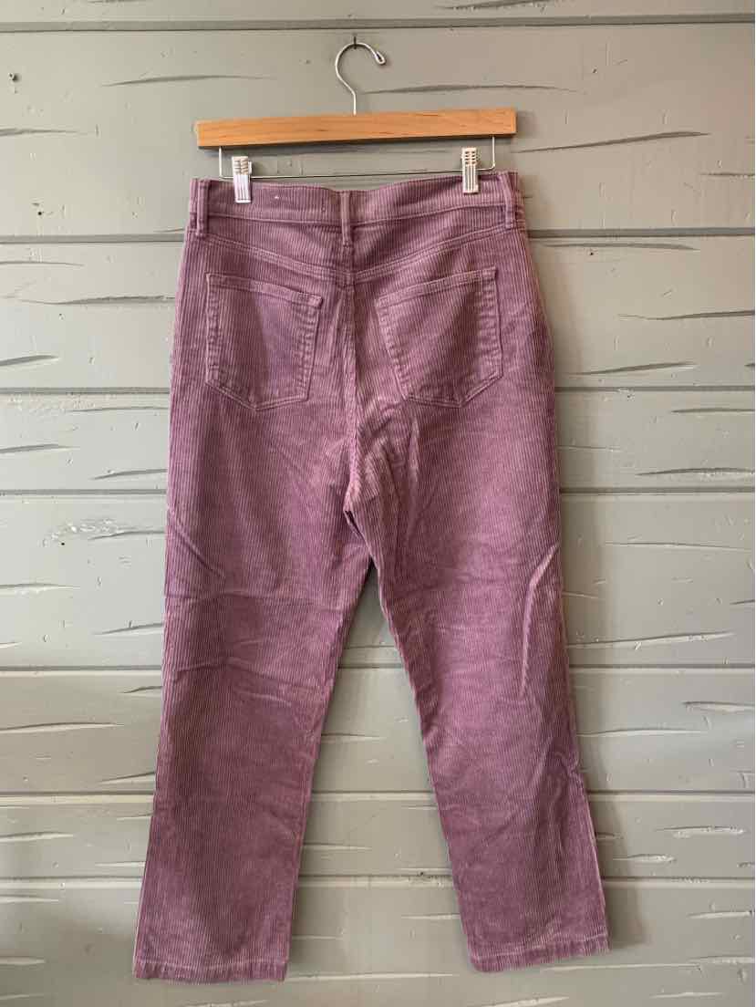 Dusty pink corduroy pants with high waist and straight leg hanging on wooden hanger.