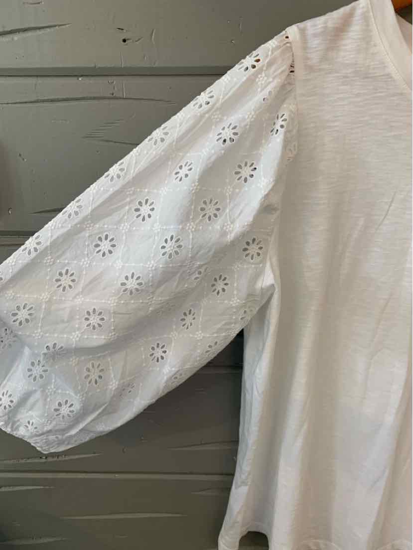 White blouse with textured fabric and puffed eyelet lace long sleeves.