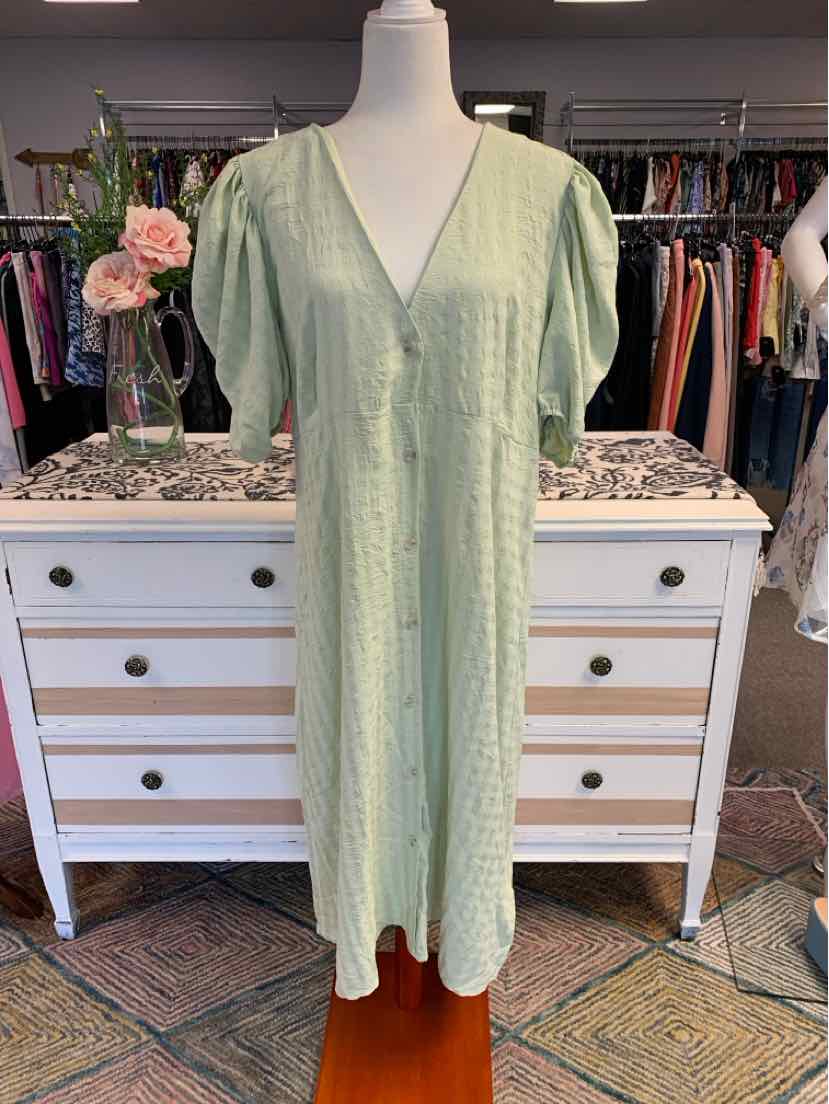 Light green midi dress with short sleeves, V-neckline, and relaxed fit on mannequin.