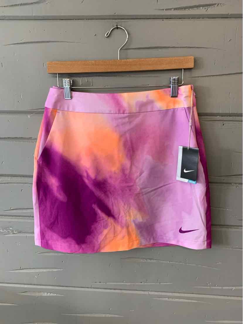 Nike women's tie-dyed skirt in purple, pink, and orange with small black Nike swoosh logo.