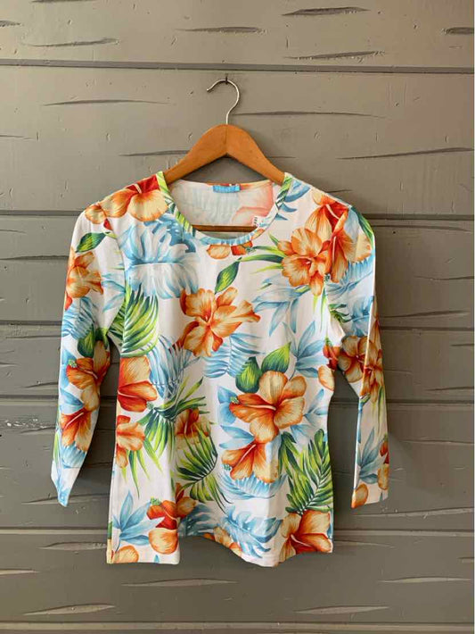Long-sleeve tropical floral print shirt with orange, blue, and green hues on white background.