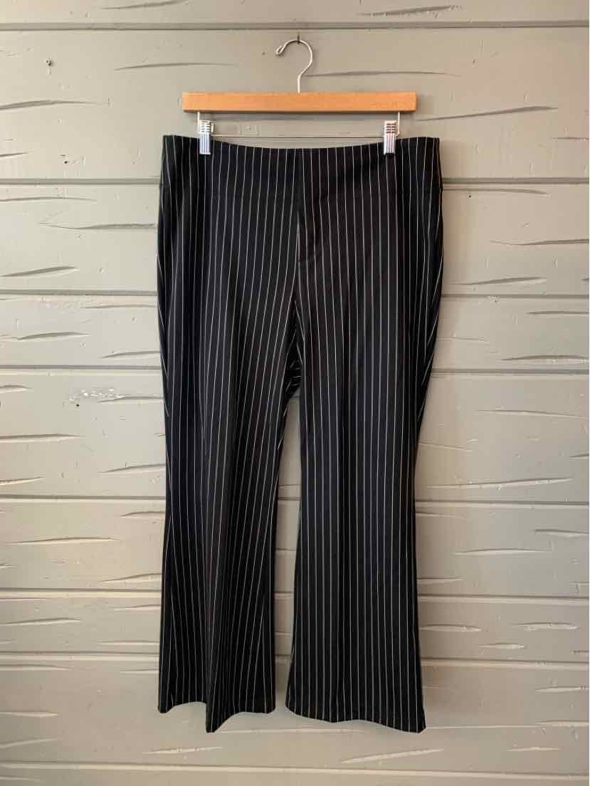 Black wide-leg pants with fine vertical white pinstripes, hanging from a clip hanger.