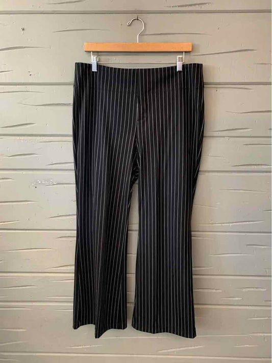 Black wide-leg pants with fine vertical white pinstripes, hanging from a clip hanger.