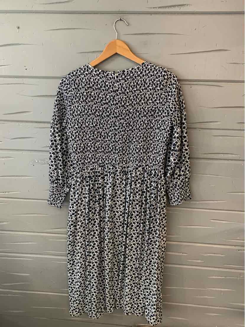 Black and white floral print midi dress with three-quarter sleeves and cinched waist on wooden hanger.