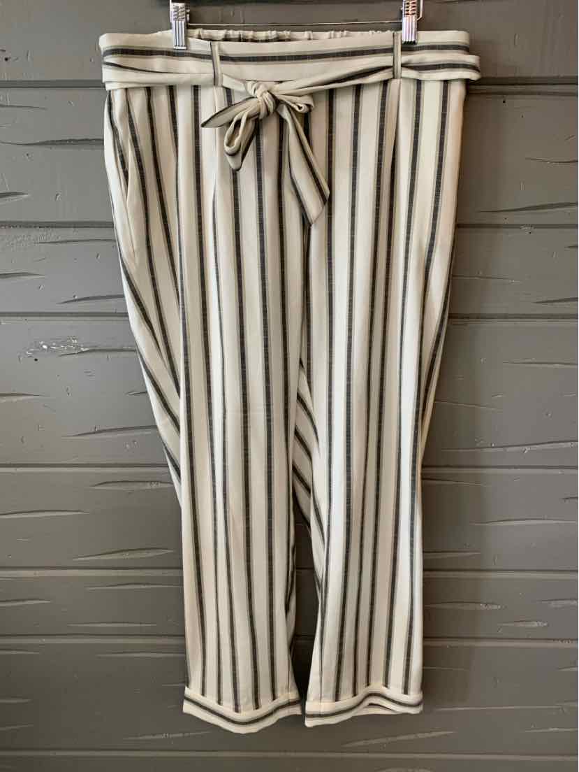 White cropped pants with vertical black stripes, drawstring waist, and relaxed fit.