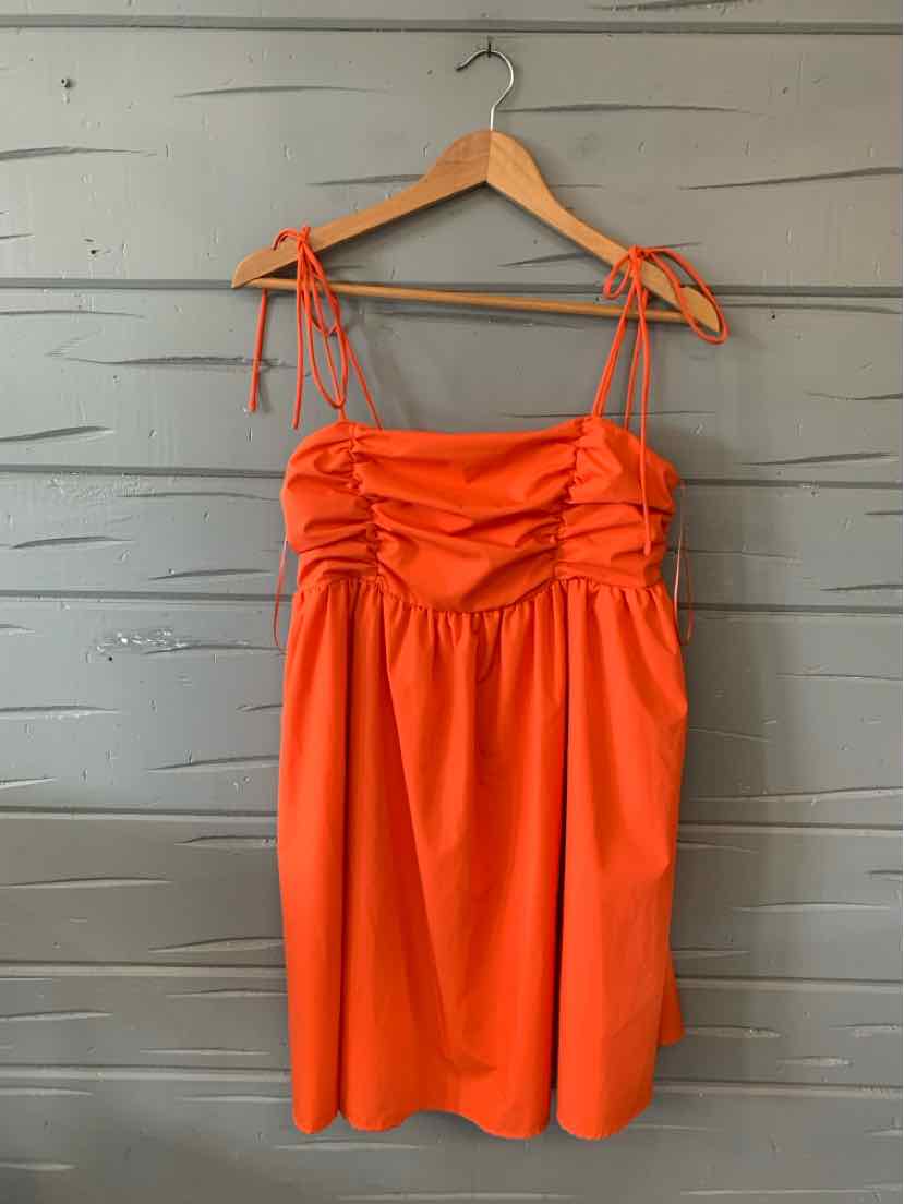 Orange sleeveless dress with ruched bodice and adjustable tie straps, knee-length hem.