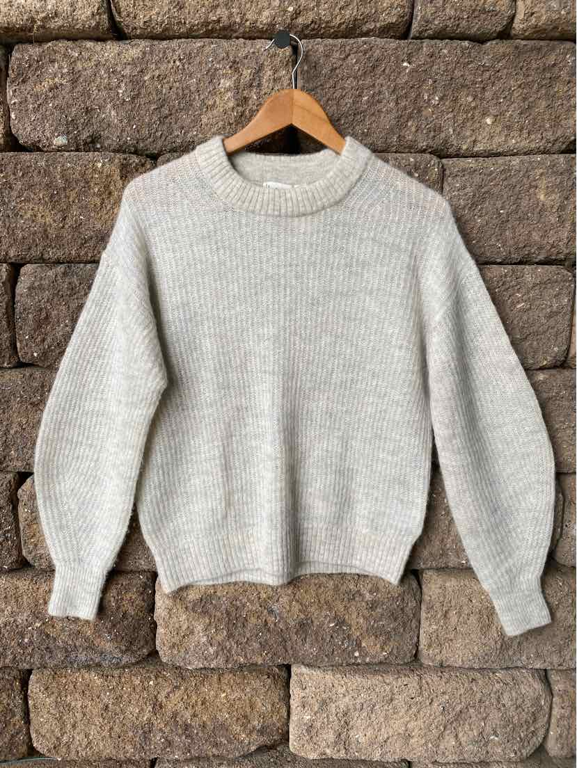 Light gray knit sweater with ribbed crew neck, cuffs, and hem, featuring a cozy, slightly oversized fit.