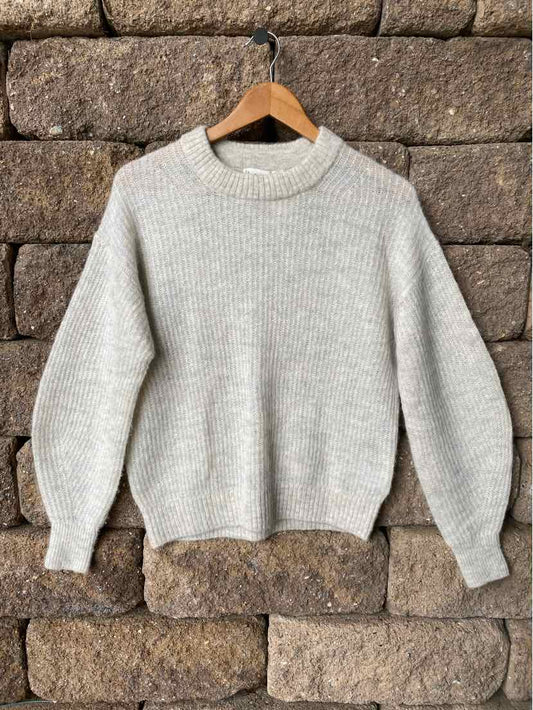 Light gray knit sweater with ribbed crew neck, cuffs, and hem, featuring a cozy, slightly oversized fit.