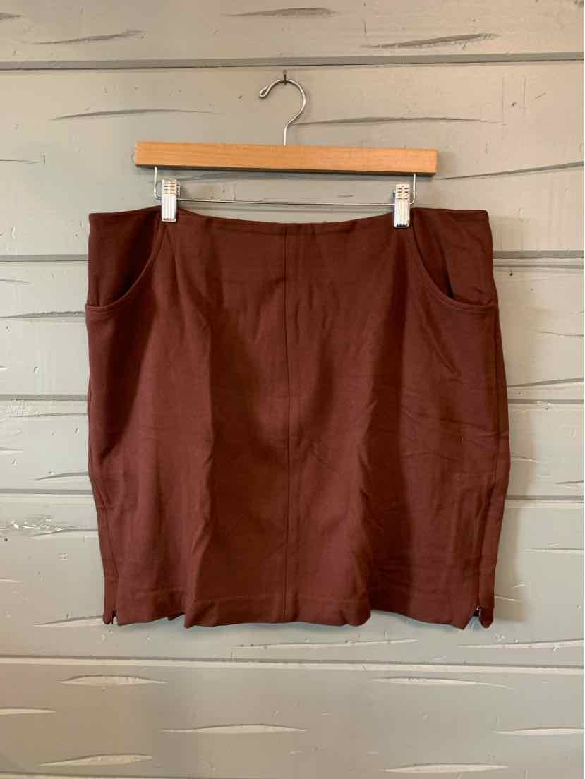 Brown knee-length straight skirt with front pockets and subtle side slits, hanging on wooden hanger.