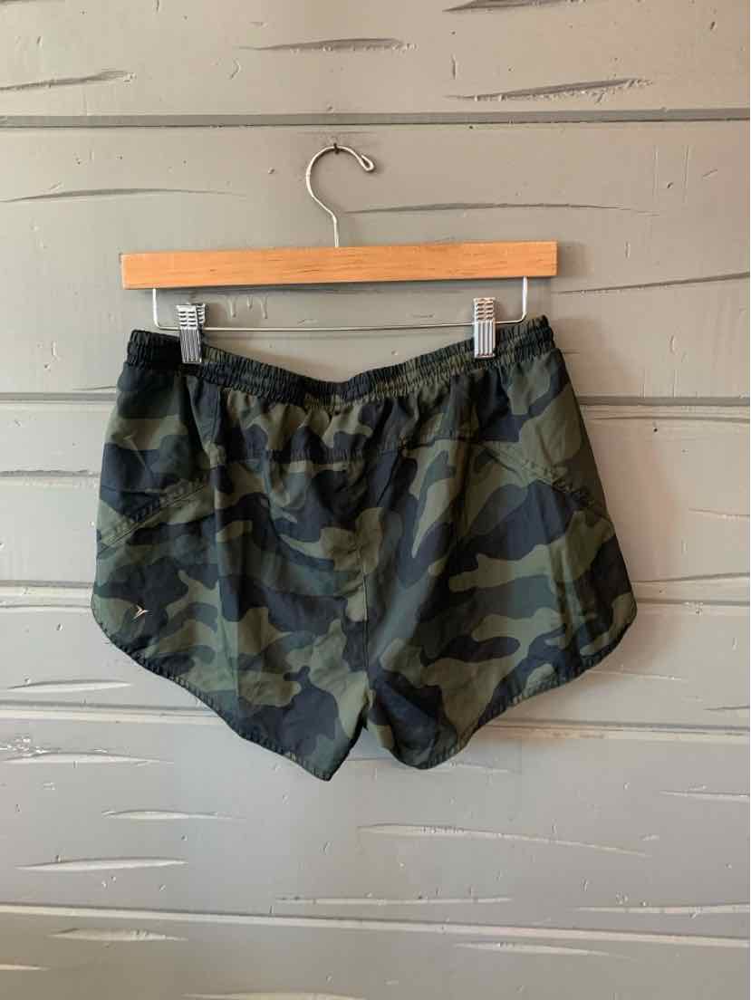 Women's green camo Old Navy shorts with elastic waistband hanging on wooden hanger.