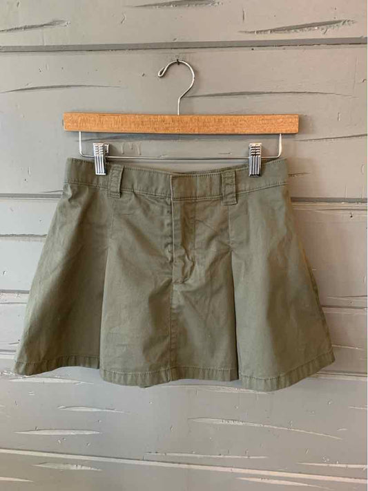 Olive green casual mini skirt with front buttons and belt loops on wooden hanger.