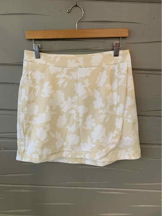 Tan floral print skirt in size 4 with a straight waistband hanging on wooden hanger.