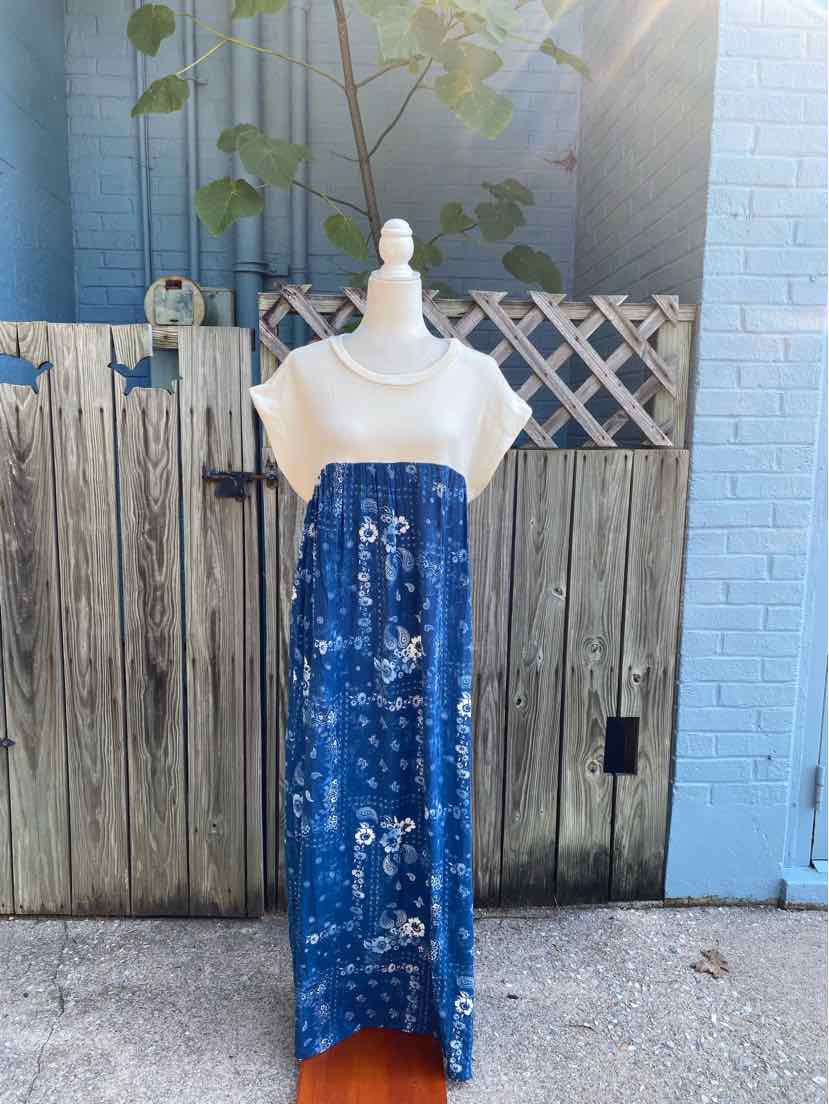 Blue sleeveless maxi dress with white paisley print and a loose, flowy fit.