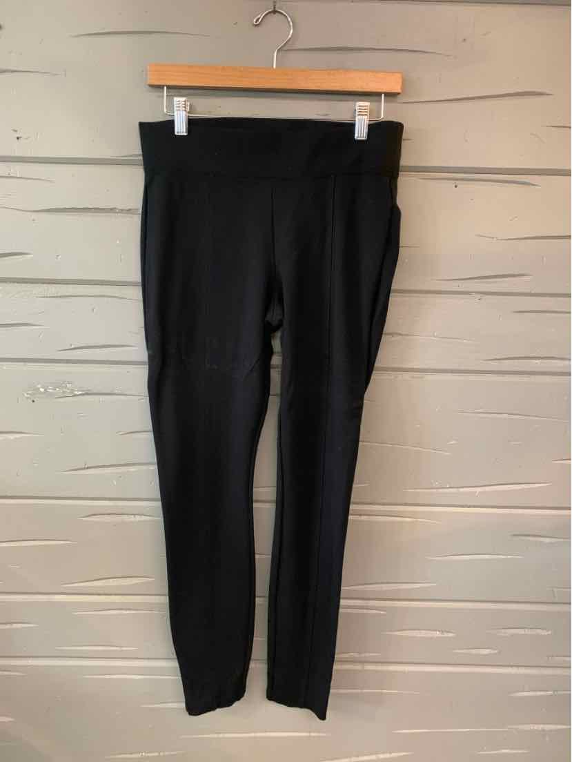 Solid black high-waist leggings with a smooth finish, medium size, hanging on wooden hanger.