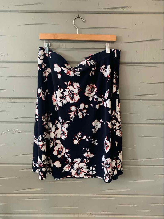 Navy blue skirt with white and pink floral print, flowy fabric, knee-length.
