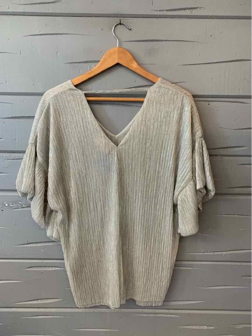 Light gray, finely textured short-sleeve top with a relaxed fit and deep V-neckline, hanging on a wooden hanger.
