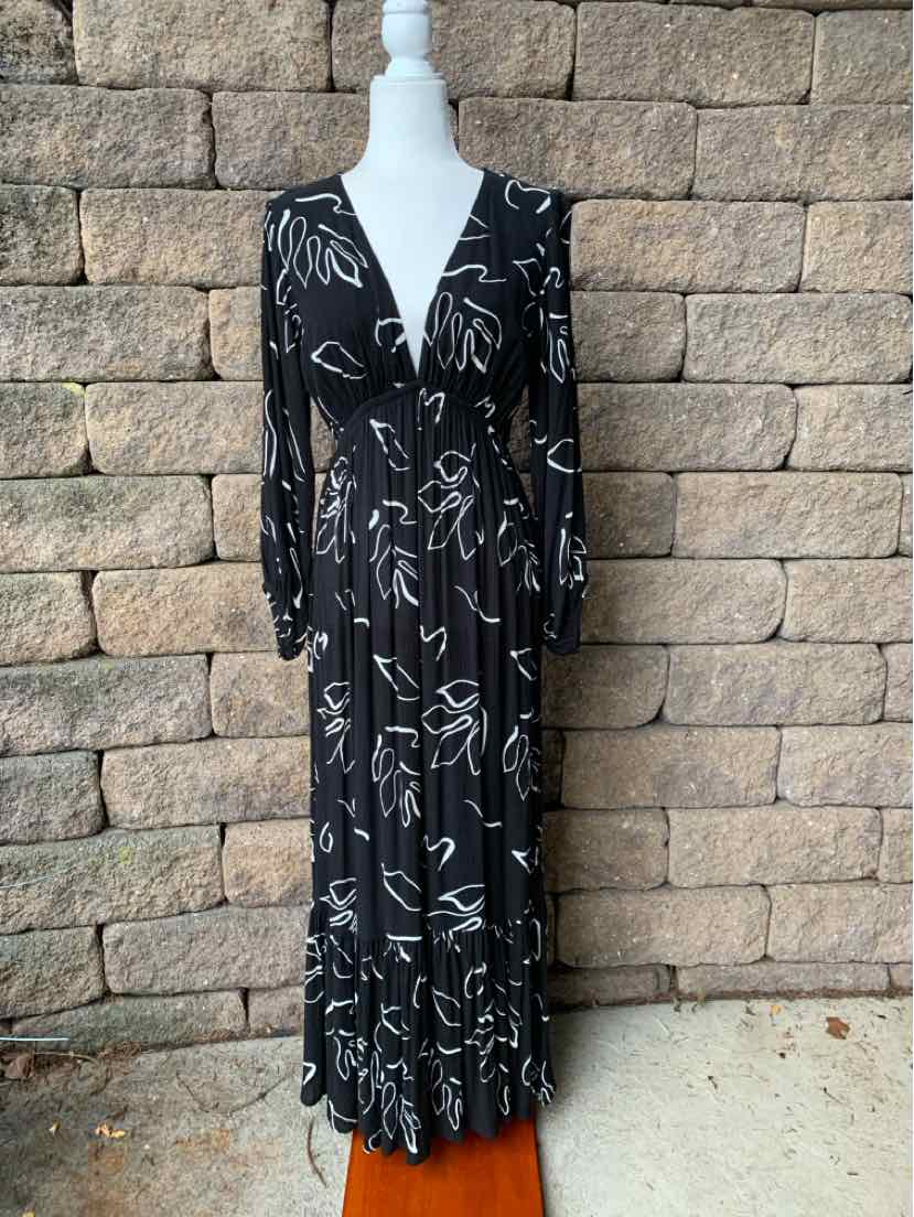 Black long-sleeve maxi dress with white floral print and V-neckline on mannequin.