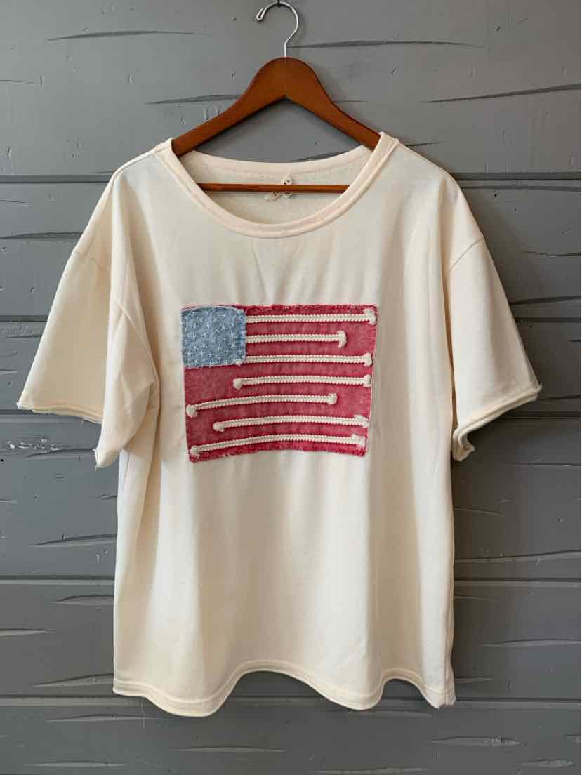 Cream short-sleeve T-shirt with abstract distressed American flag design in red, white, and blue, size large.
