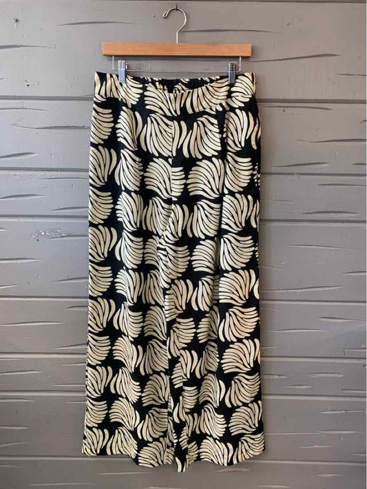 Black wide-leg pants with white tropical leaf print and elastic waistband.