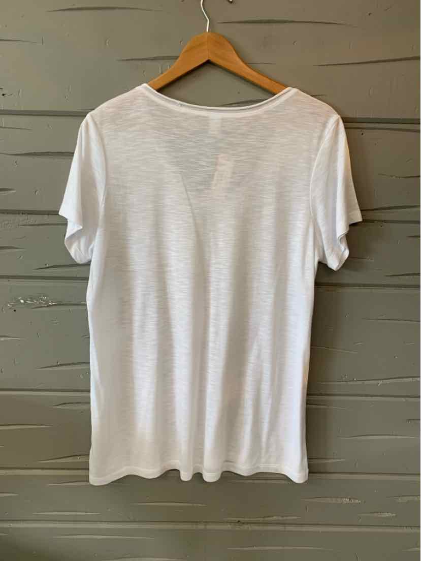 White short-sleeve cotton T-shirt with a relaxed fit, hanging on wooden hanger against gray wall.