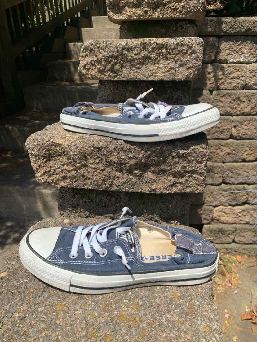 Blue low-top Converse sneakers with white rubber soles and laces, size 9.