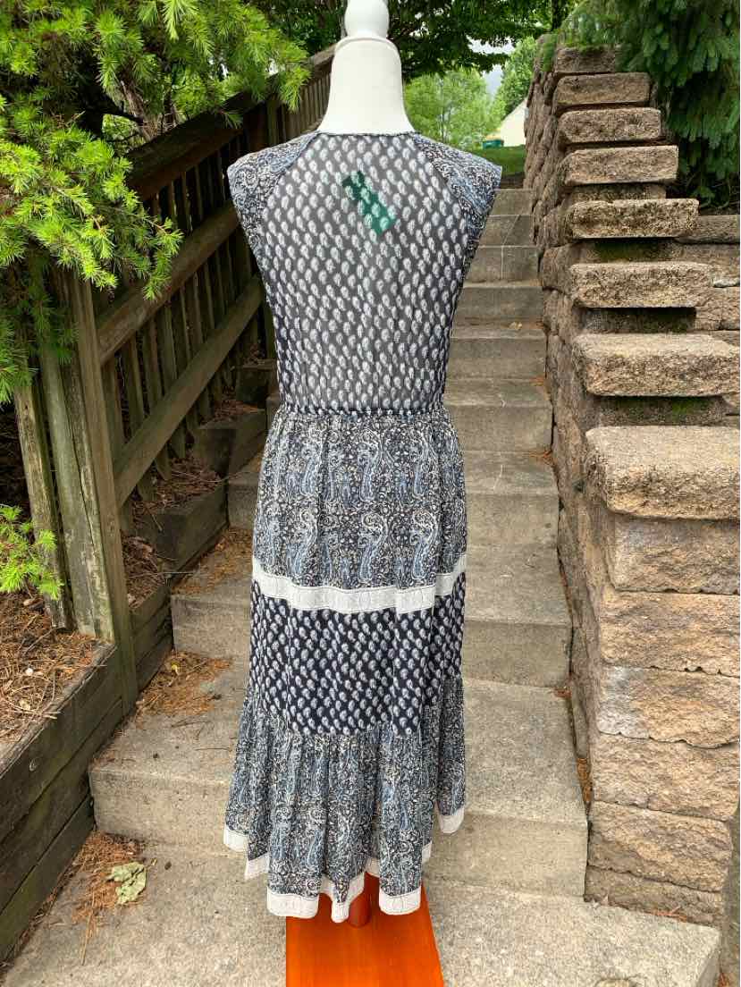 Sleeveless midi dress with blue and white paisley print and tiered skirt on mannequin outdoors.