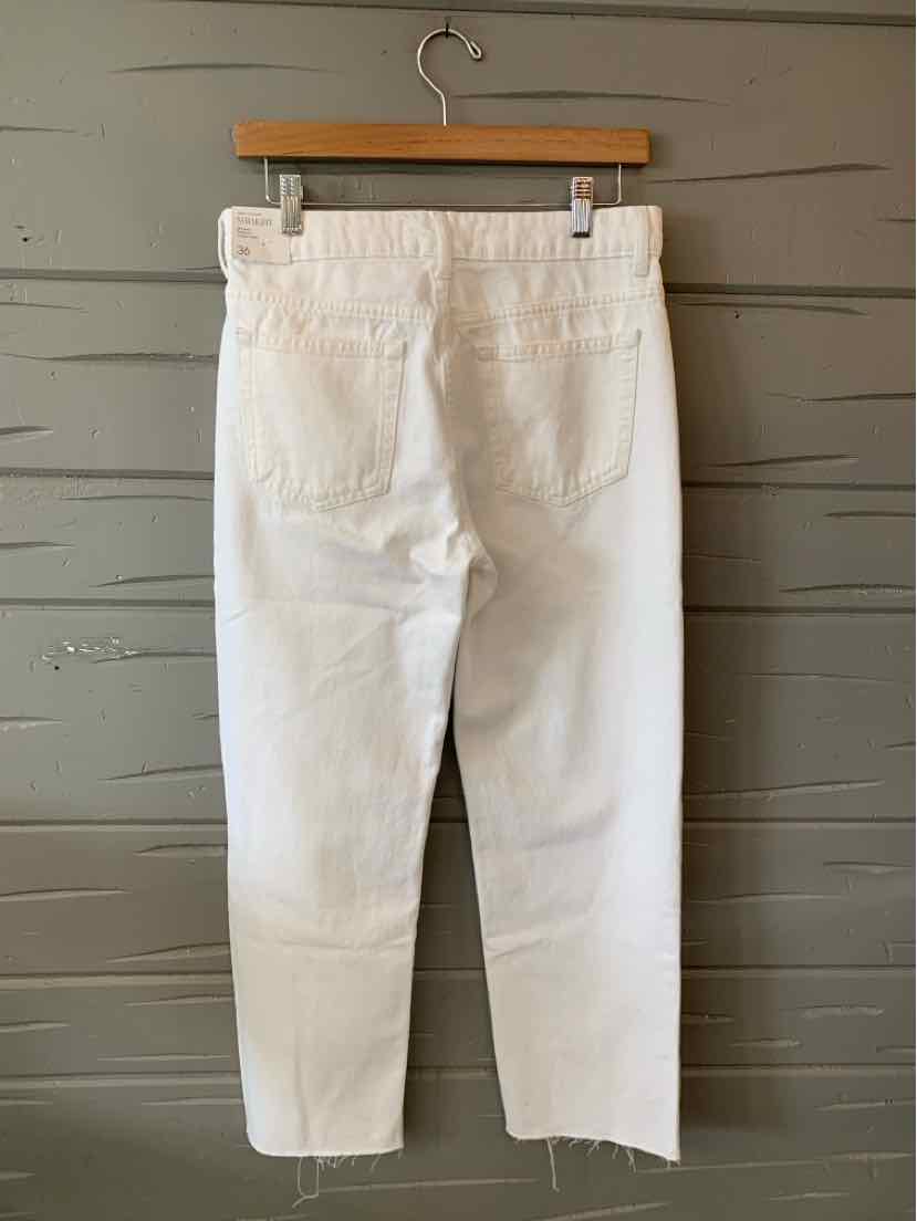 White denim jeans with a straight-leg cut, high waist, and two back pockets hanging on a wooden hanger.