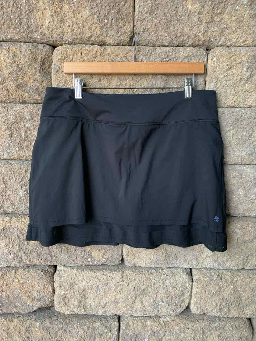 Black athletic skirt with built-in shorts, wide waistband, and subtle logo on hem.