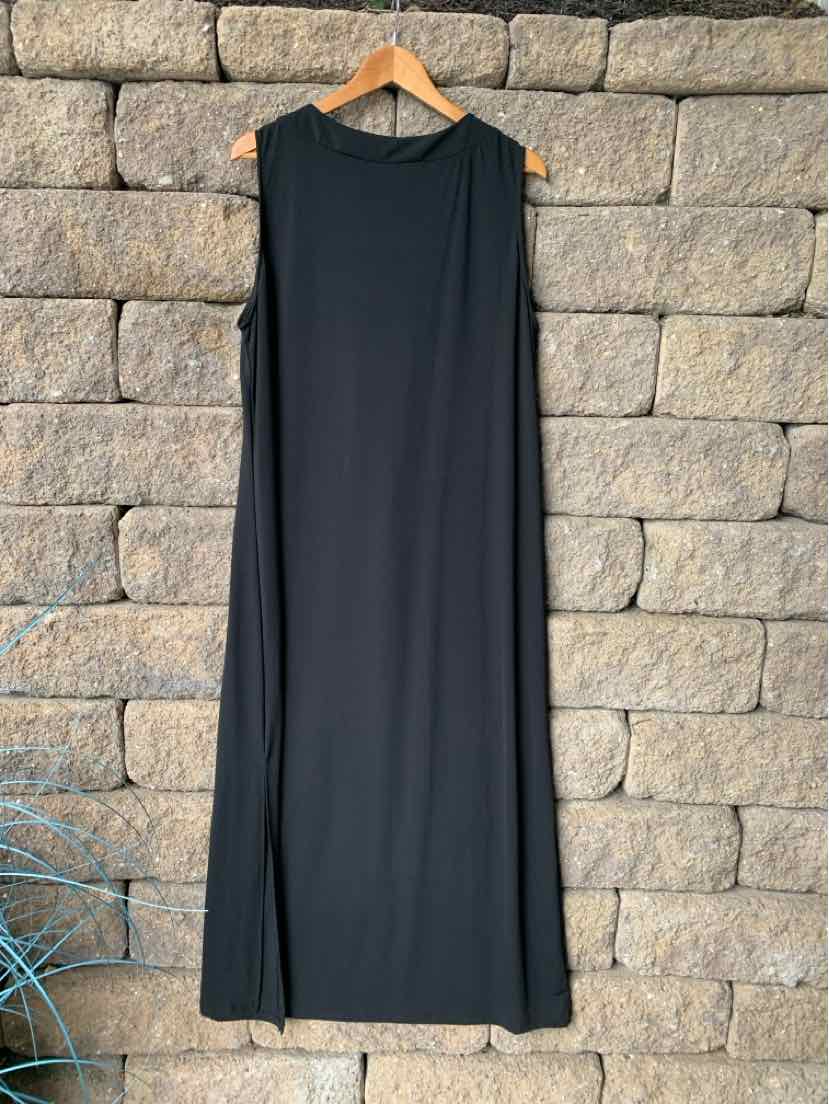 Black sleeveless maxi dress with a straight cut and round neckline hanging on wooden hanger.