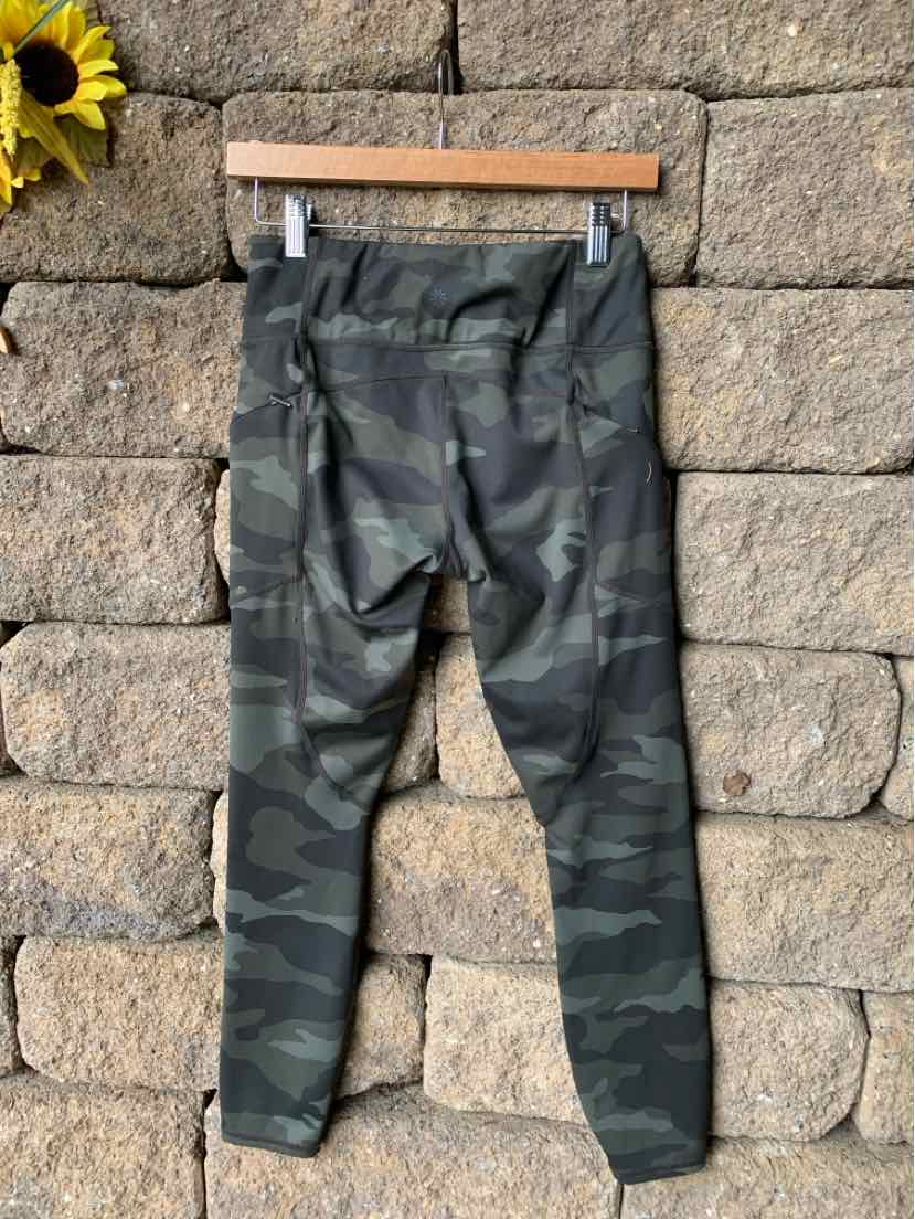 Women's camo print leggings in shades of dark green and black with a high waistband.