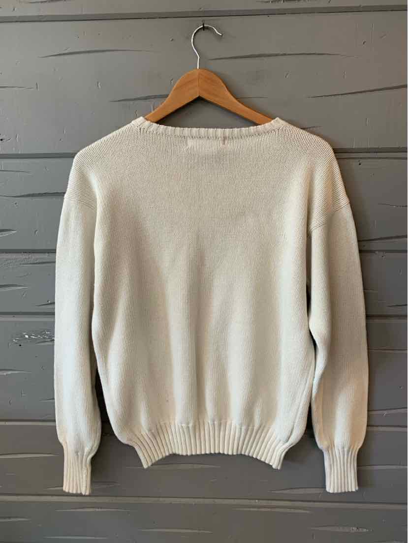 Cream white wool sweater with ribbed cuffs, hem, and collar on wooden hanger.