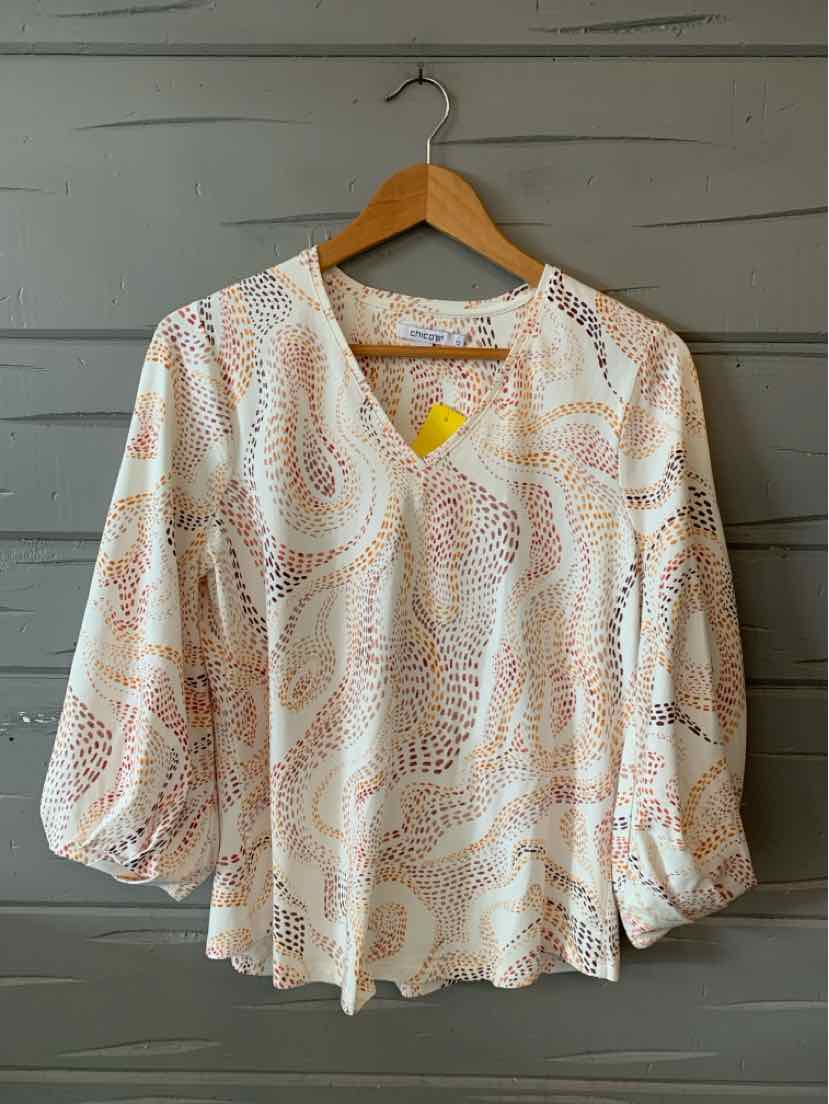 White blouse with light pink and orange paisley pattern, V-neck, and billowy three-quarter sleeves.