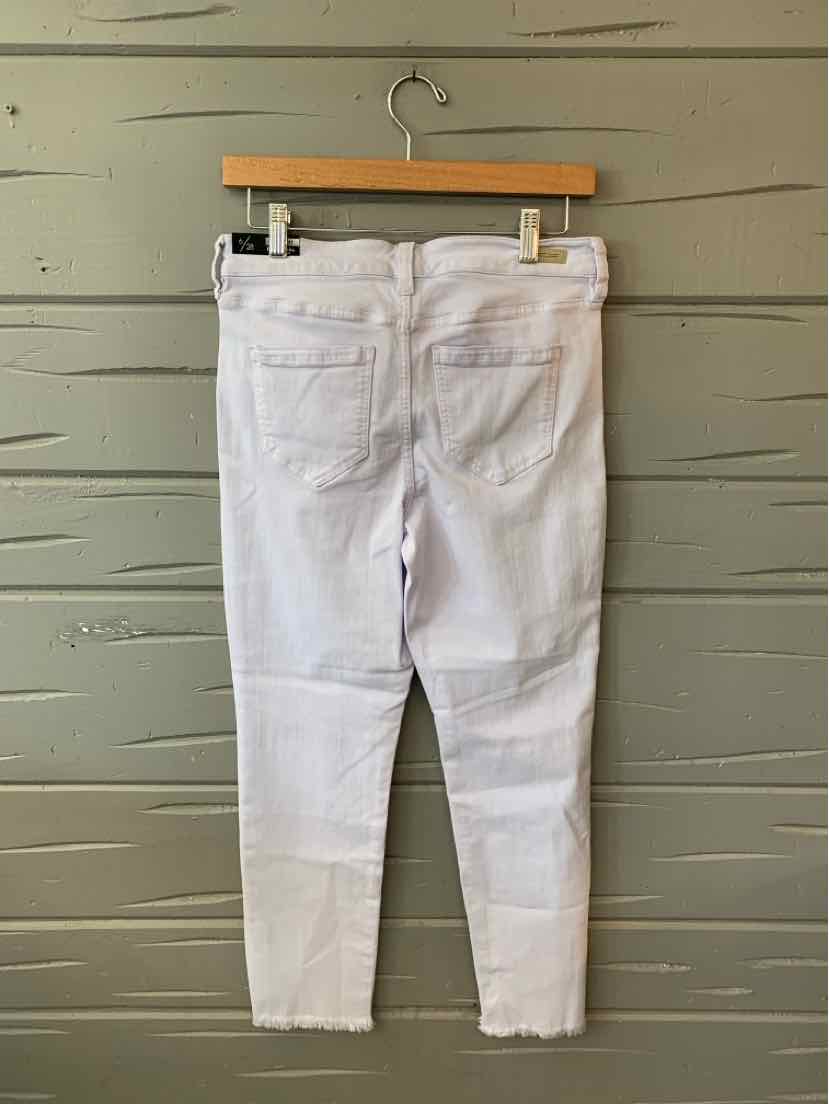 White slim-fit jeans with two back pockets and a straight waistband hanging on a wooden hanger.