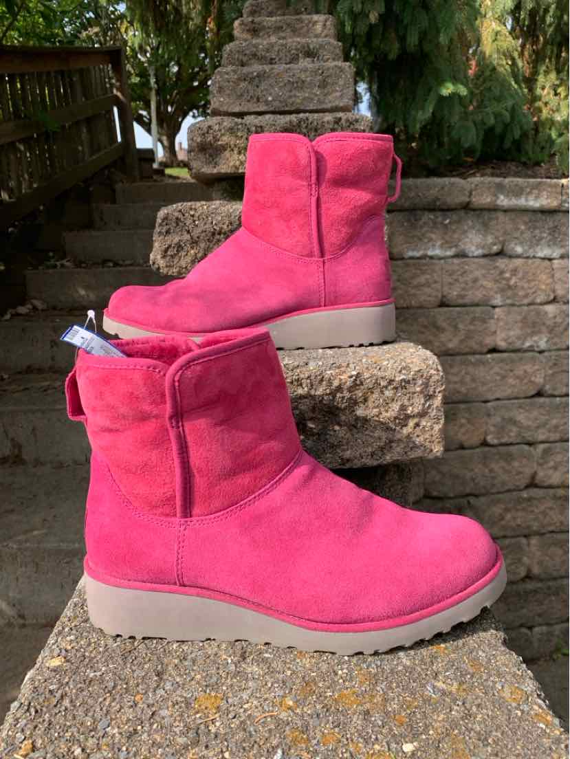 Bright fuchsia suede UGG ankle boots with plush lining, stitched panels, and beige rubber soles.
