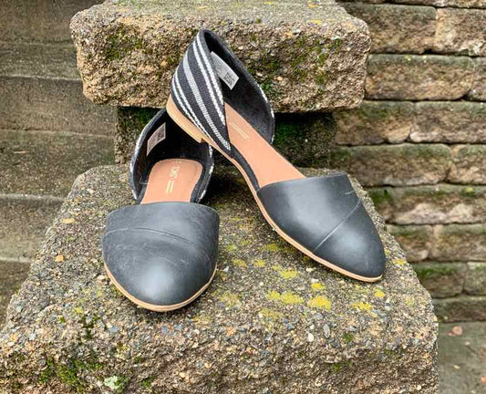 Black TOMS women's slip-on shoes with pointed toes and striped fabric backs, size 8.5.