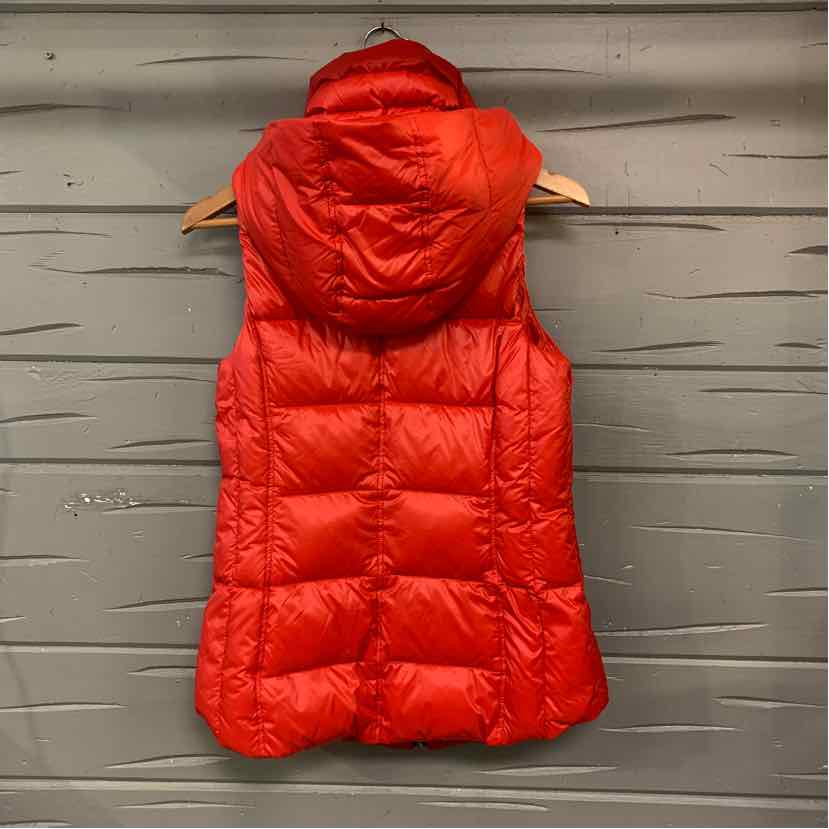 Bright red quilted sleeveless anorak with padded hood and rear stitching details.