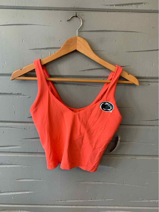 Coral cropped tank top with wide straps and a small black and white Penn State logo patch on the left chest.