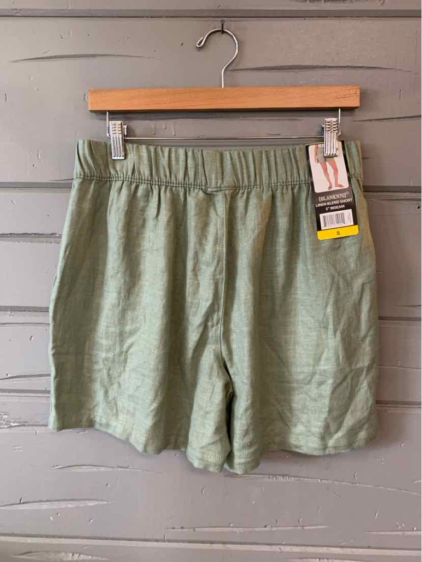 Light green casual shorts with elastic waistband and hanging retail tags.