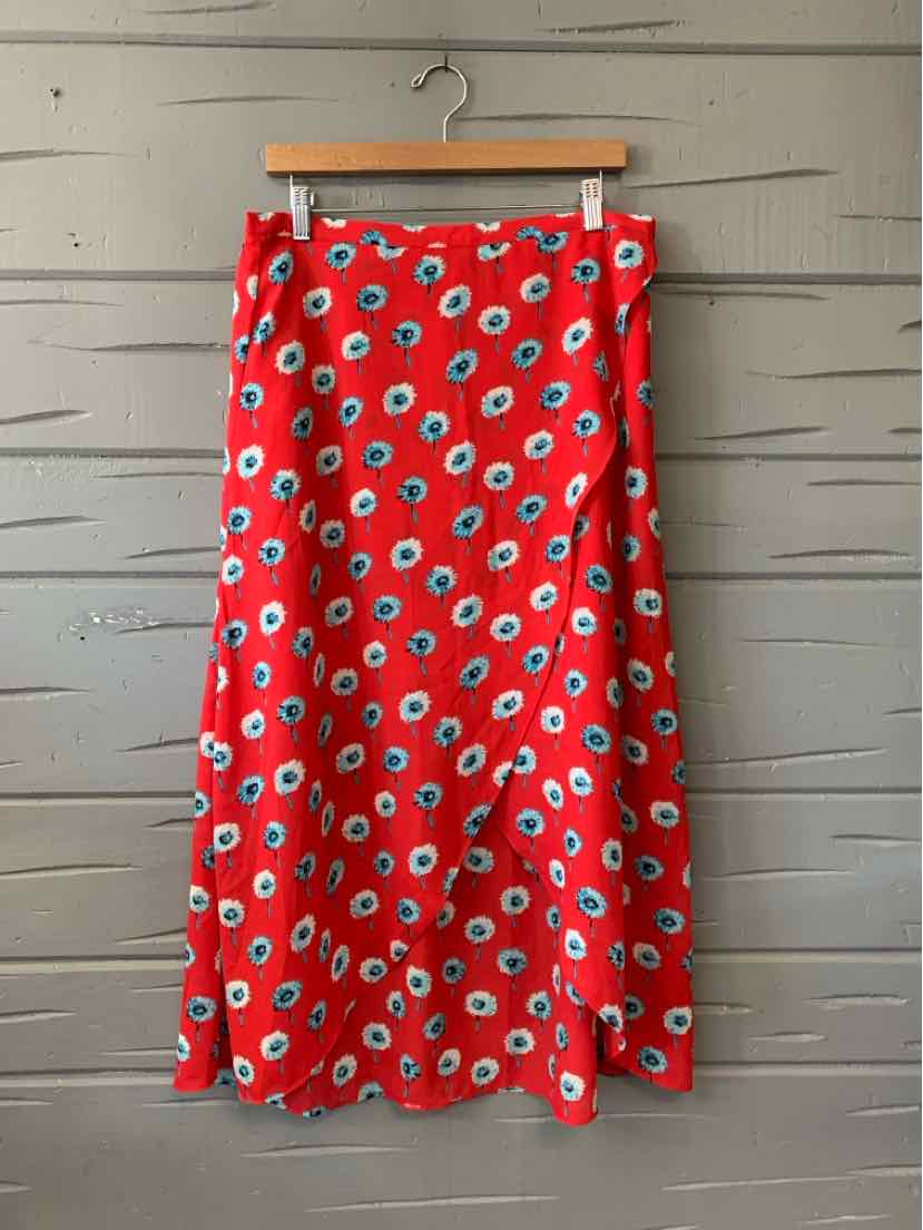 Red midi skirt with blue and white floral print, button details at the waist, hanging on wooden hanger.