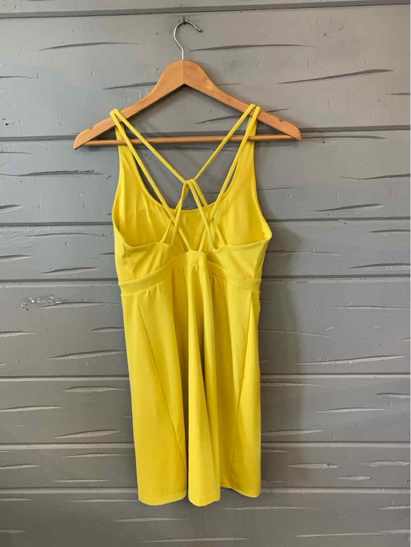 Bright yellow sleeveless dress with thin double straps and fitted bodice on wooden hanger.